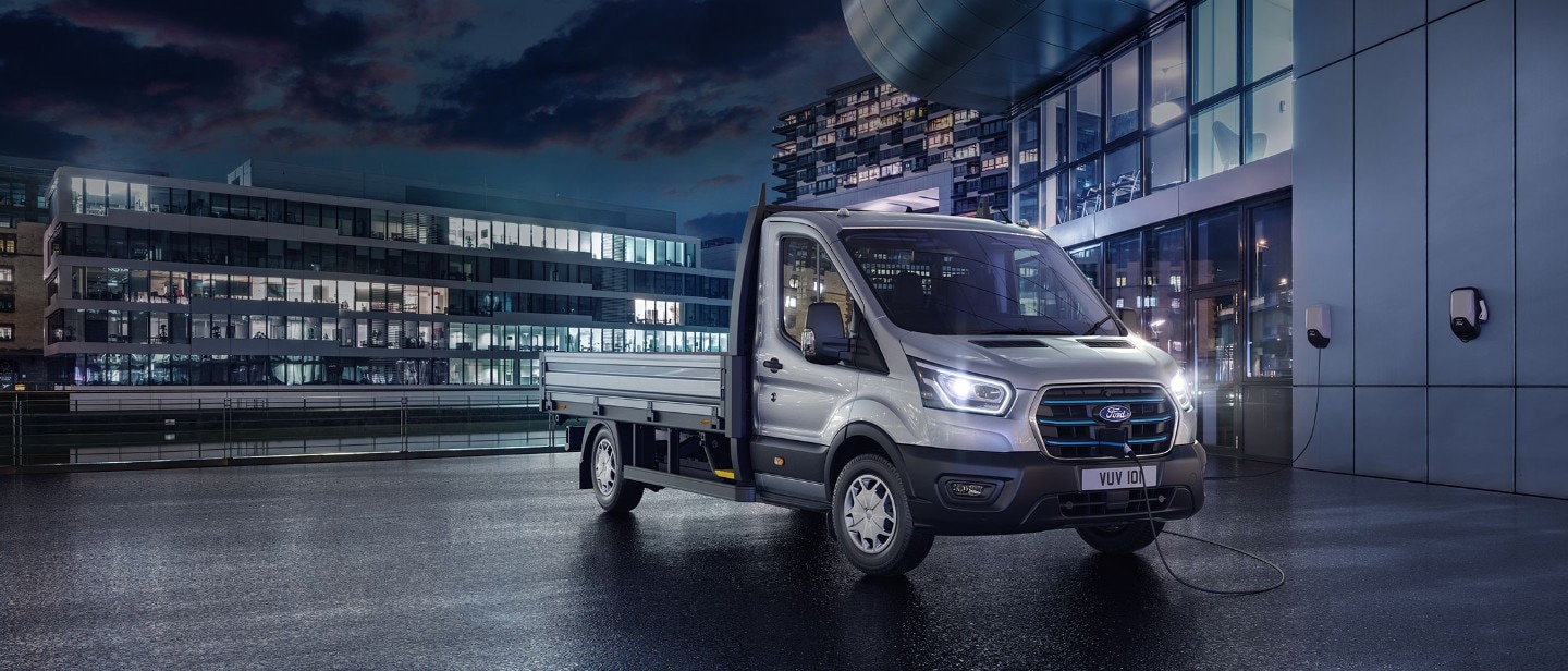 New E-Transit side view with the backdrop of city in night with blue electric lights