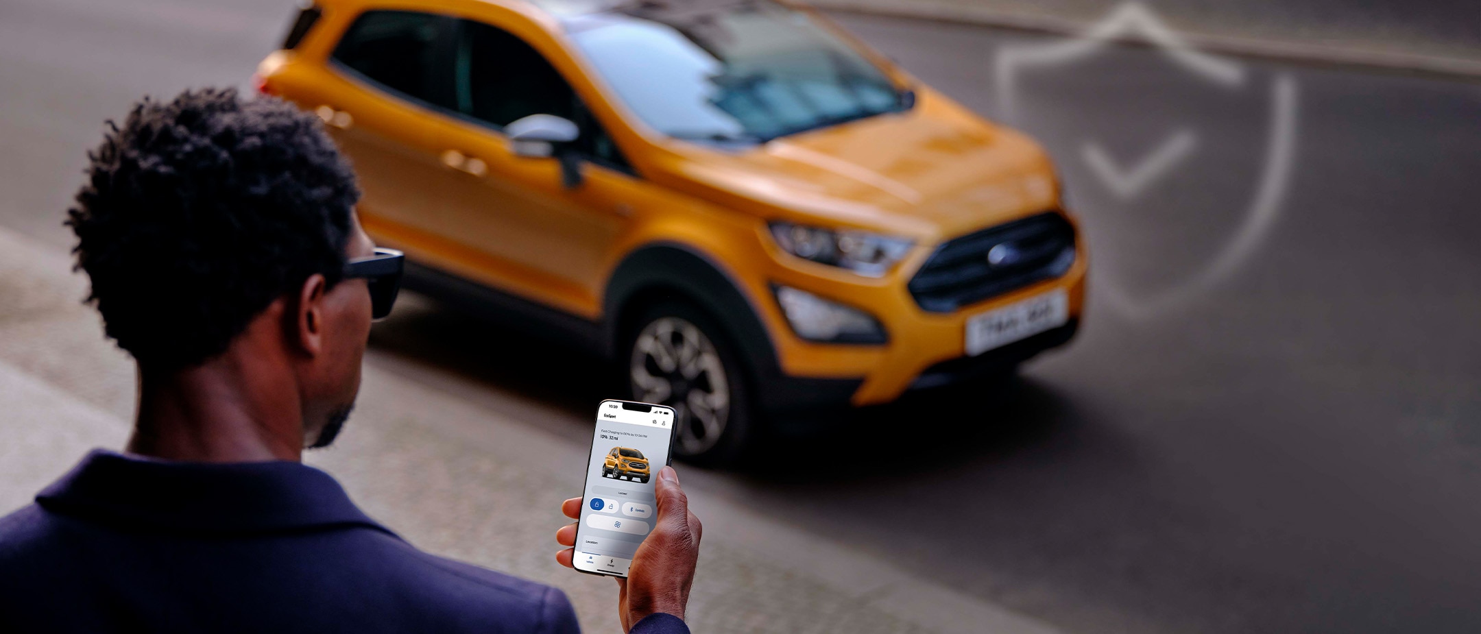 Man with phone checking app in mobile near Ford EcoSport